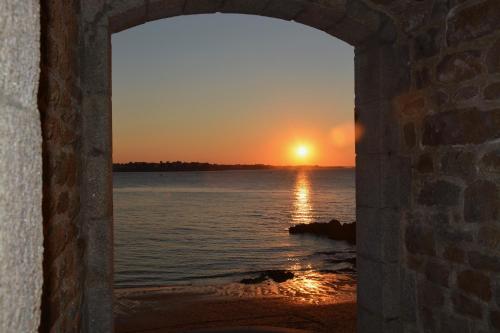 a view of the sunset through a stone archway at Gites Bijoux in Argouges
