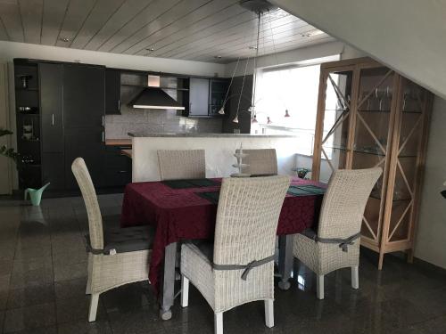 a dining room with a table and chairs and a kitchen at Weinurlaub in Sulzfeld am Main