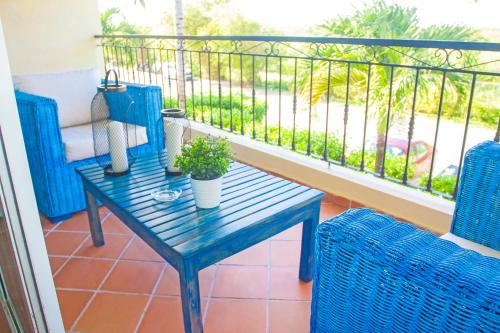 una mesa azul y 2 sillas en un balcón con vistas en Cocotal Bavaro Apartments, en Punta Cana