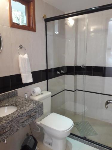 een badkamer met een douche, een toilet en een wastafel bij Pousada Pedacinho do Céu in Conservatória