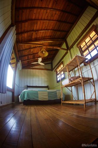 a bedroom with a bunk bed and a ladder at Pousada Watu Kerere in Praia do Rosa