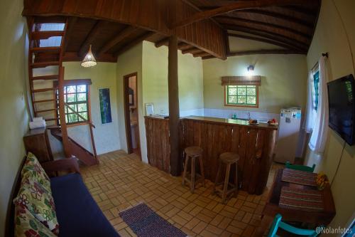 a room with a kitchen with a counter and a counter top at Pousada Watu Kerere in Praia do Rosa