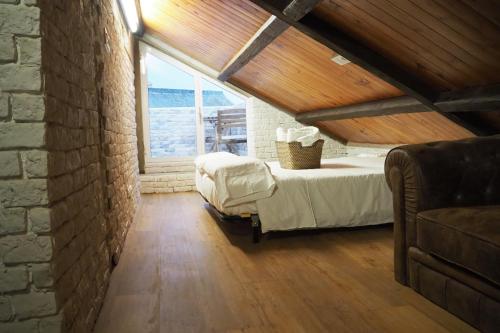 a bedroom with a bed and a large window at Tiny and cute apartment in the roof touching border in La Línea de la Concepción