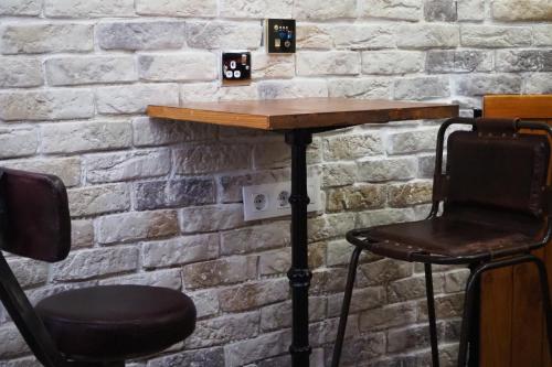 a table and two chairs in front of a brick wall at Tiny apartment on the roof touching Gibraltar in La Línea de la Concepción