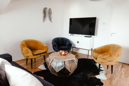 a living room with two chairs and a table at Luxury Apartments Zelny Trh in Brno