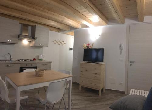 uma cozinha com uma mesa e uma televisão num quarto em South Lagoon Apartments 1 em Chioggia