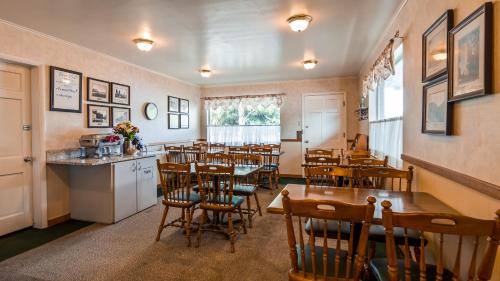 a dining room with tables and chairs in a restaurant at Baugh Motel, SureStay Collection by Best Western in Logan