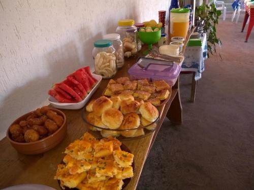 uma mesa coberta com pratos de alimentos e bebidas em Pousada Só Alegria em Mario Campos