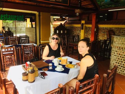 two women sitting at a table eating food at Hoang Giang Homestay in Ninh Binh