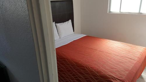 a bedroom with a bed with red sheets and a window at Guest Harbor Inn- Port Of Los Angeles San Pedro in San Pedro