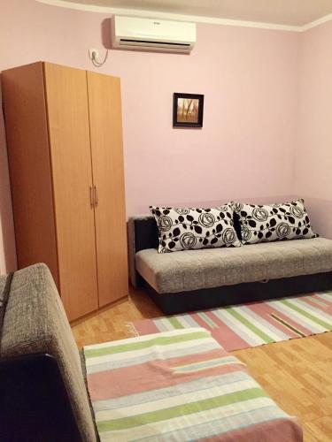 - un salon avec un canapé et une armoire dans l'établissement Apartmani Milanovic Susanj, à Bar