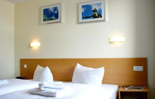 a bedroom with two white towels on a bed at Familienhotel Citylight in Berlin