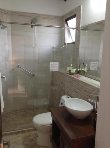 a bathroom with a toilet and a glass shower at HOTEL LA POSADA DEL ZAGUÁN in El Retiro