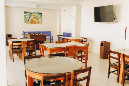 a room with tables and chairs and a flat screen tv at Bungalows Las Hamacas in San Patricio Melaque