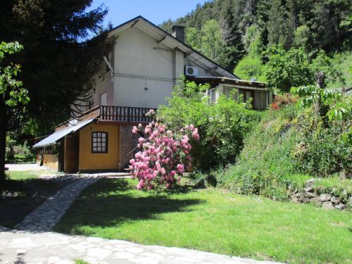 una casa con flores rosas delante de un patio en Sacromonte Apart, en San Martín de los Andes