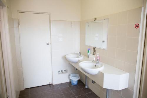a bathroom with two sinks and a mirror at Royal Hotel Wyong in Wyong