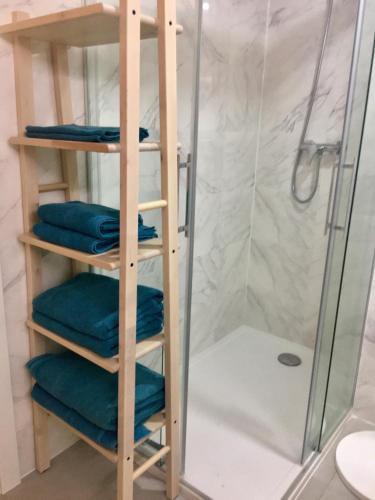 a towel rack with four blue towels in a shower at Buddha house in Torrox Costa