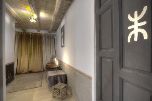 a hallway with a door and a table in a room at Jardin de la source in Aït Yous