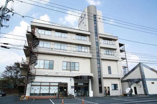 a large white building with a lot of windows at Hotel Jodai in Unnan