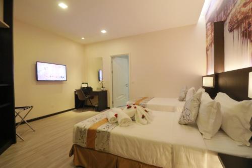 a hotel room with a bed with towels on it at Amamas Boutique Hotel Kuching in Kuching