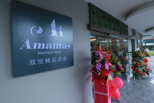 a sign on the side of a store with flowers at Amamas Boutique Hotel Kuching in Kuching