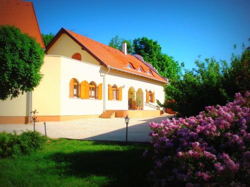 a white house with an orange roof and some flowers at Napvirág-Ház in Zsira