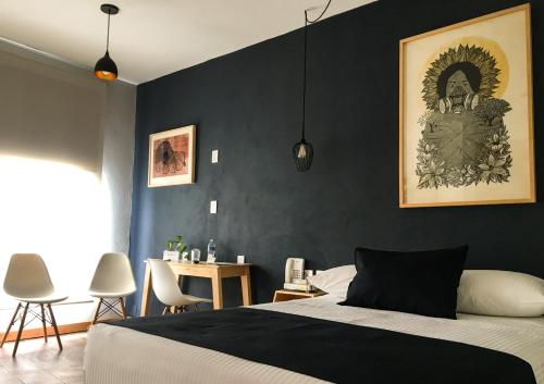 Hotel Romance Morelia في موريليا: غرفة نوم بحائط لهجة سوداء وسرير