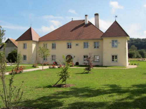 a large house with a large yard with green grass at Le relais des deux tours in Brémondans