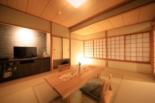 a living room with a table and a tv at Tensui Saryo in Hakone