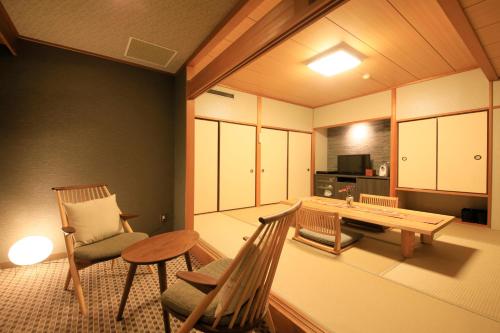 a room with two chairs and a table and a dining room at Tensui Saryo in Hakone