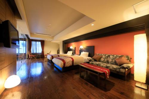 a hotel room with a bed and a couch at Tensui Saryo in Hakone