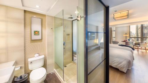 un bagno con un water e un letto in una stanza di SSAW Boutique Hotel Ningbo CBD a Ningbo
