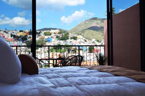 a bedroom with a bed and a view of a city at Hotel Corazón Mexicano in Guanajuato