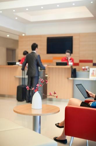 a man standing in an office with a table and people at Ibis Barcelona Santa Coloma in Santa Coloma