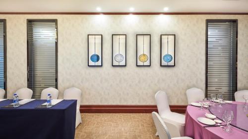 a dining room with two tables and white chairs at SSAW Boutique Hotel Ningbo CBD - Family Friendly & Business Travel in Ningbo