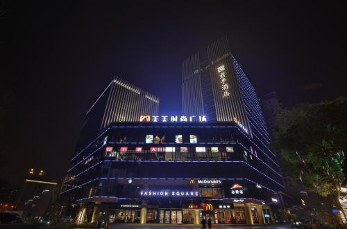 a tall building with a sign on it at night at SSAW Boutique Hotel Wenzhou Jiushan Lake in Wenzhou