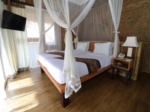 a bedroom with a bed with a mosquito net at Biyukukung Suite & Spa in Ubud