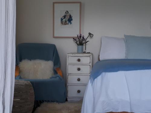 - une chambre avec un lit, une chaise et une commode dans l'établissement Mapua Studio Quality Accommodation, à Mapua