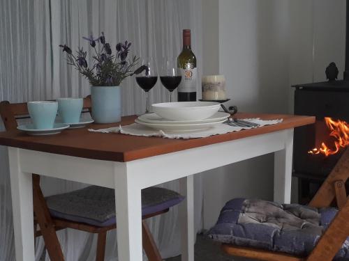 a table with plates and glasses and a bottle of wine at Mapua Studio Quality Accommodation in Mapua