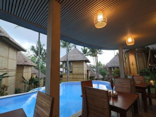a patio with a table and chairs and a pool at Biyukukung Suite & Spa in Ubud