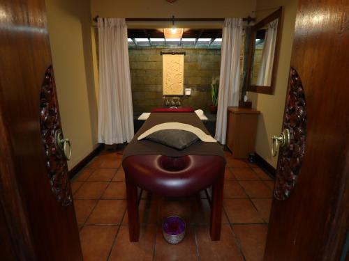 a bedroom with a bed and a stool in a room at Biyukukung Suite & Spa in Ubud
