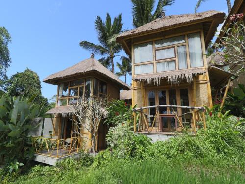 an old house with a thatched roof at Biyukukung Suite & Spa in Ubud