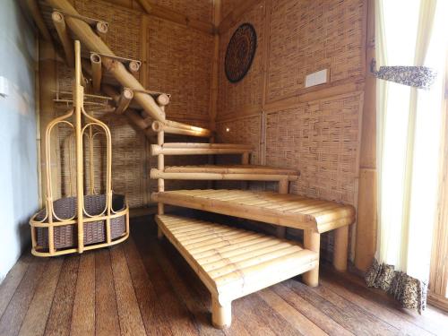a wooden room with a wooden staircase and a bench at Biyukukung Suite & Spa in Ubud