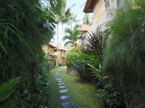 a garden path with rocks in front of a building at Biyukukung Suite & Spa in Ubud