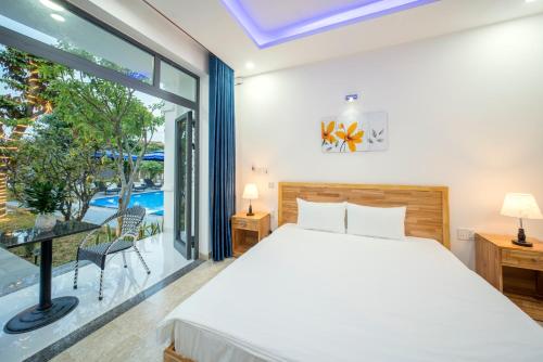 a bedroom with a bed and a large window at Tran Family Villas Boutique Hotel in Hoi An