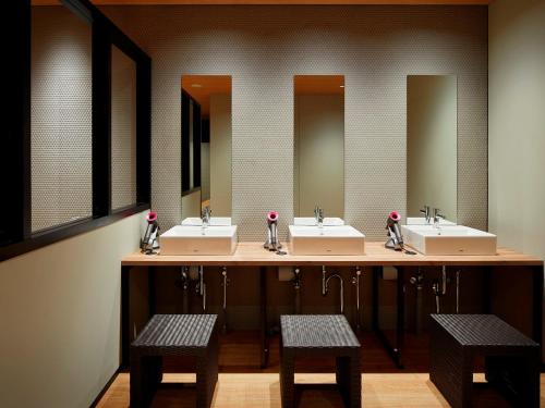 a bathroom with three sinks and three mirrors at hotel androoms Shin-Osaka in Osaka