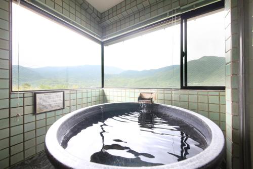 a bath tub in a room with a window at Tensui Saryo in Hakone