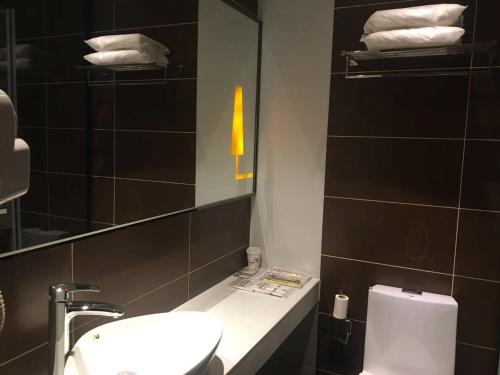 a bathroom with a sink and a mirror and a toilet at IU Hotel Beijing Life Science Park Station in Changping