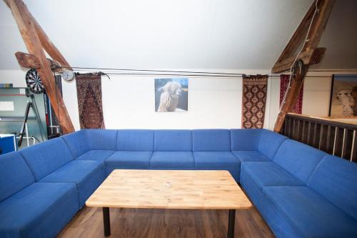 a blue couch in a living room with a table at Norrängens Alpacka - Det lilla boutiquehotellet med en fluffy twist ! in Sala