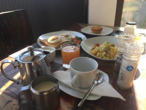 a wooden table topped with plates of food and drinks at Villa Alizee in Port Louis